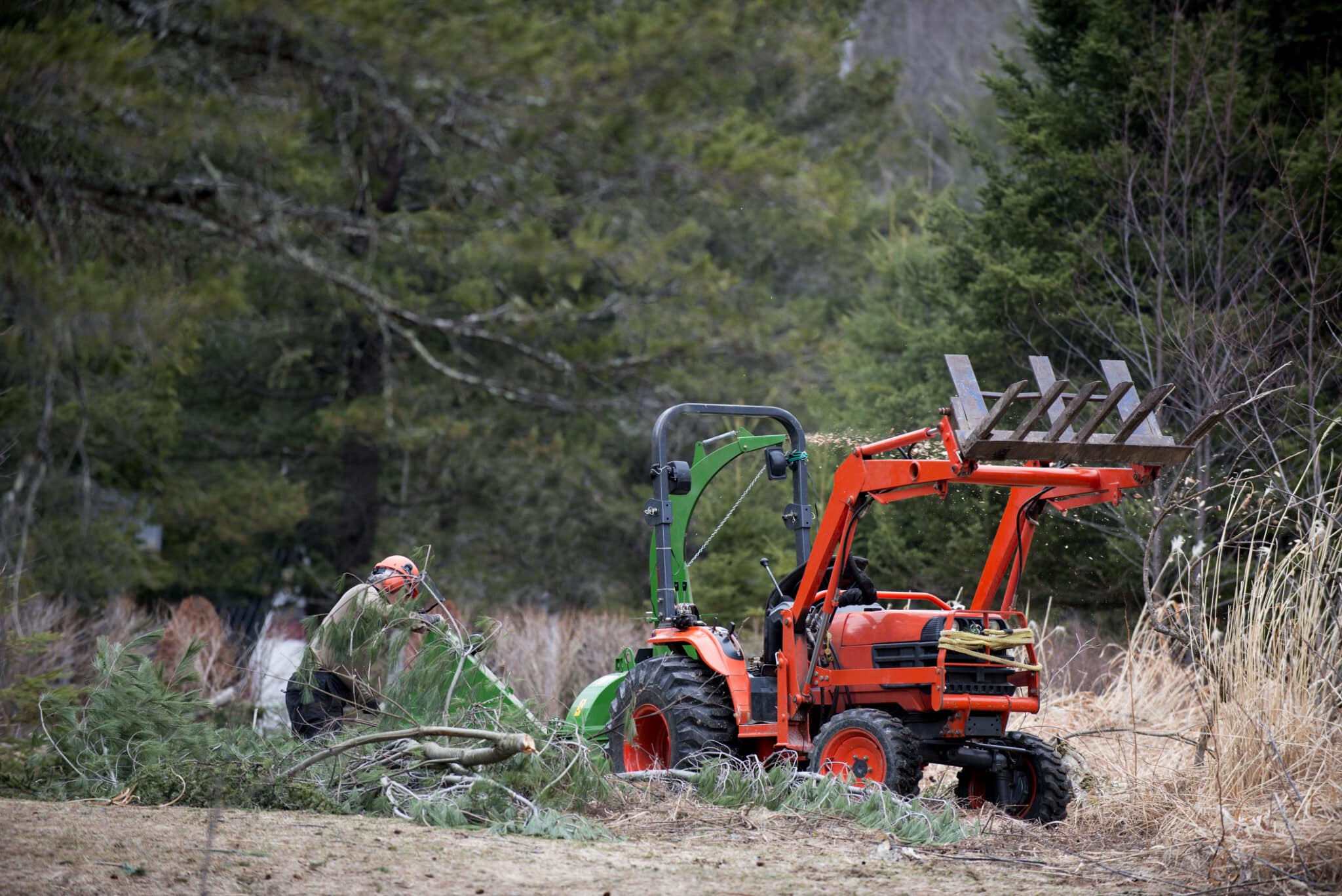 Men working with wood chipper and tractor
