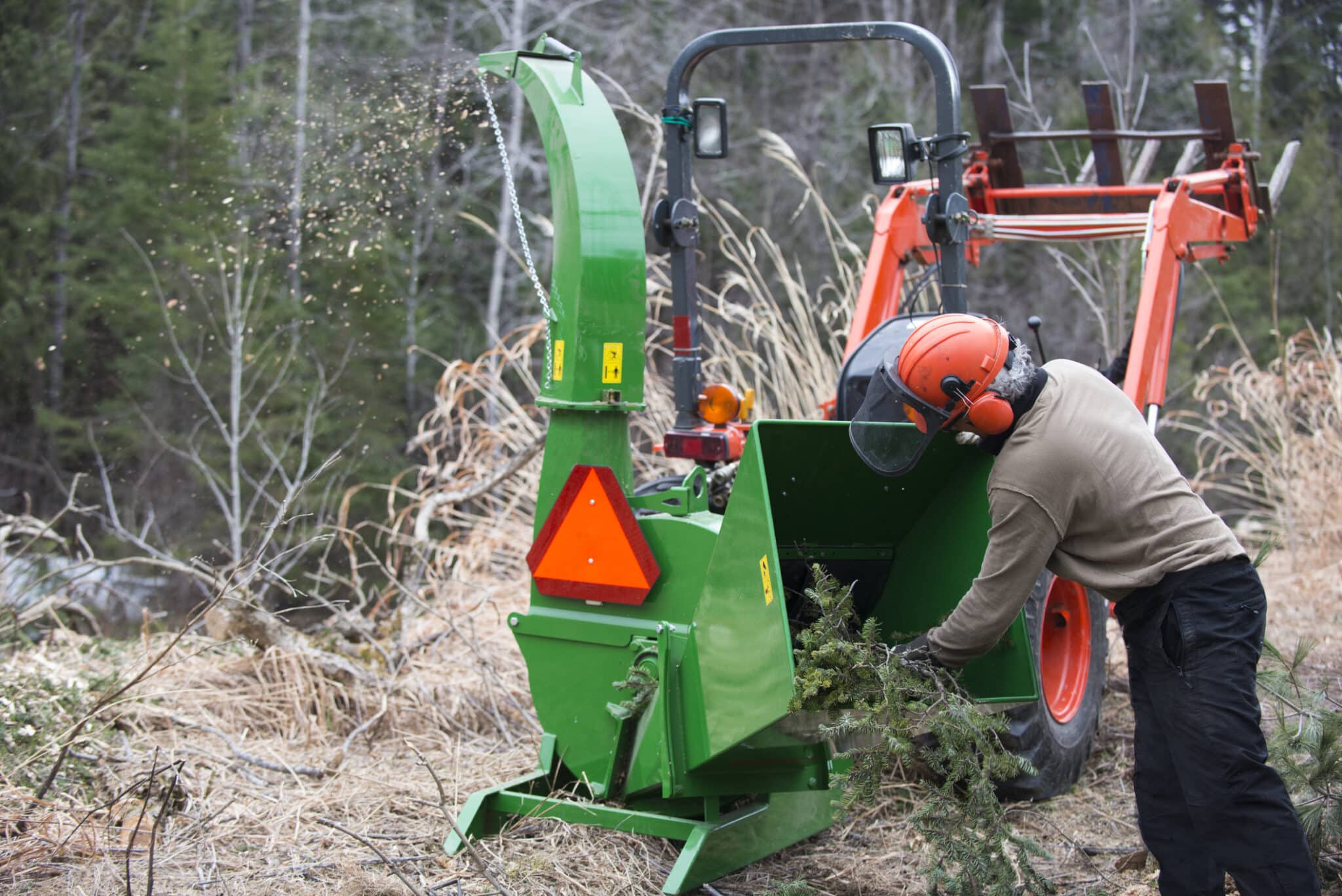 Men working with wood chipper and tractor